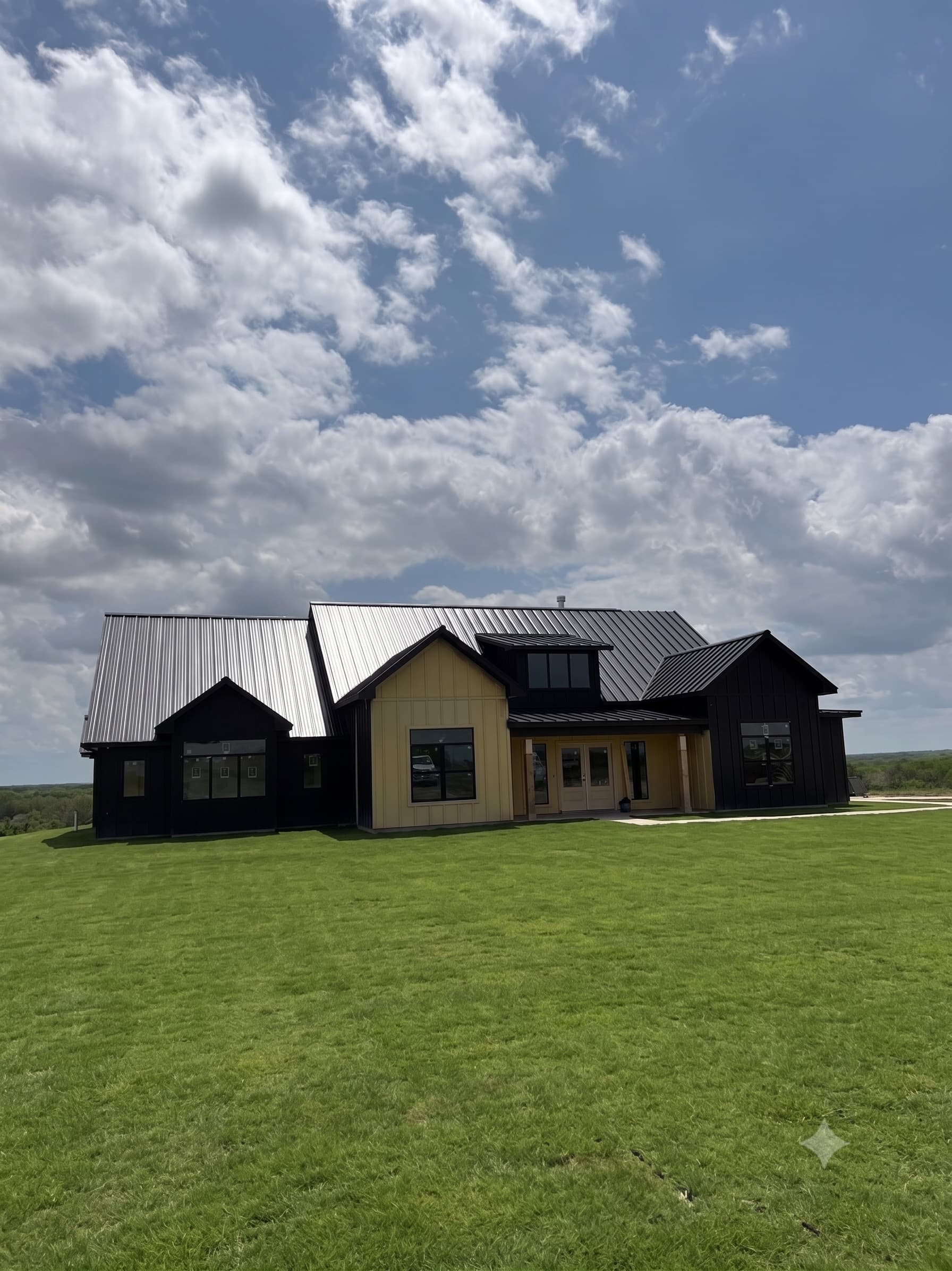 Replacement in Tomball: New standing seam metal roof on a modern farmhouse build.